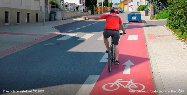 Ilustrace k otázce: Cyklistovi, který dává znamení o změně směru jízdy proto, aby mohl přejet z vyhrazeného jízdního pruhu pro cyklisty do průběžného pruhu, řidič jedoucí v přilehlém pruhu:
